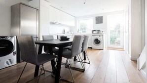 A modern kitchen with a dining area, built-in appliances, and a large window. - The Jericho Escape - Comfortable & Modern 4BDR in Jericho (Oxford)