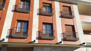 A multi-story building with balconies, a sign for "Hostal Jijones," and a visible entrance. - Hostal Jijones (Villarrubia de los Ojos)