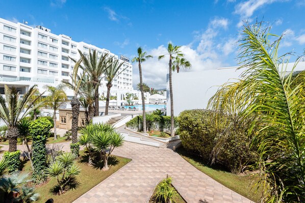 A hotel with a pool, palm trees, and a clear blue sky. - Sahara Hotel Agadir (Agadir)