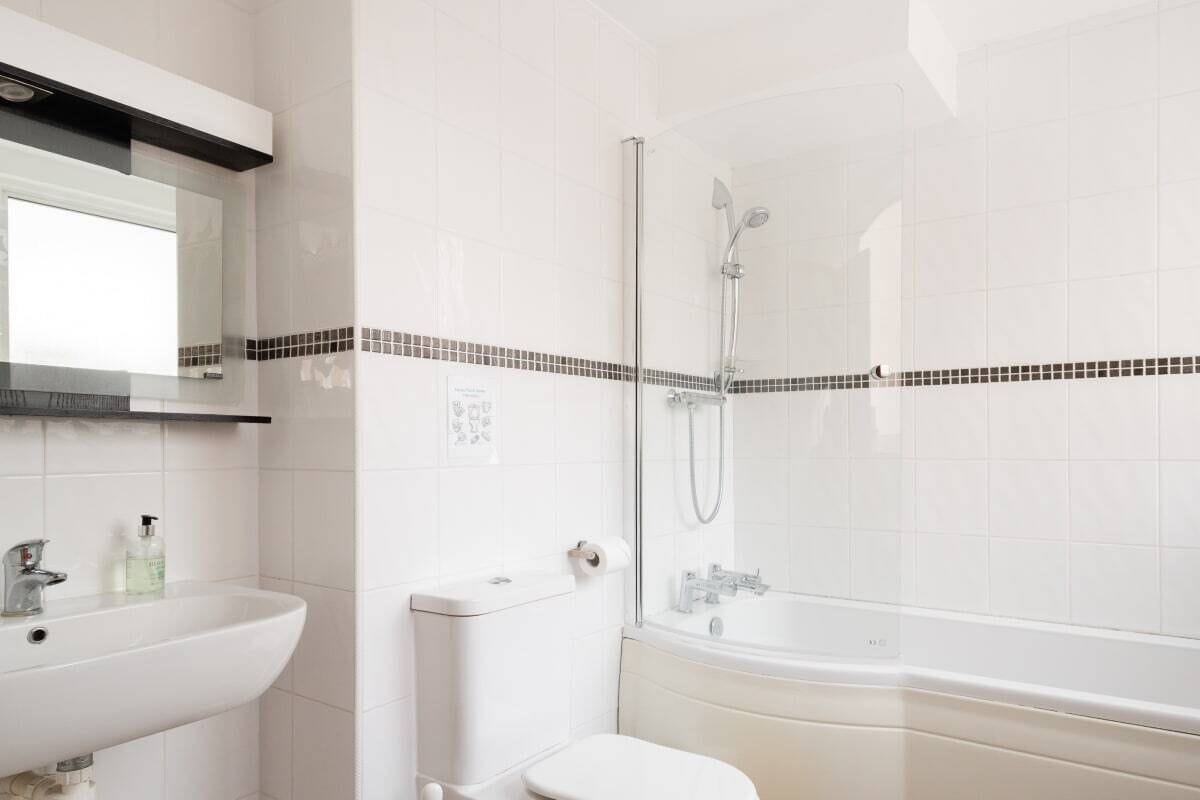 A bathroom with a sink, toilet, and bathtub.