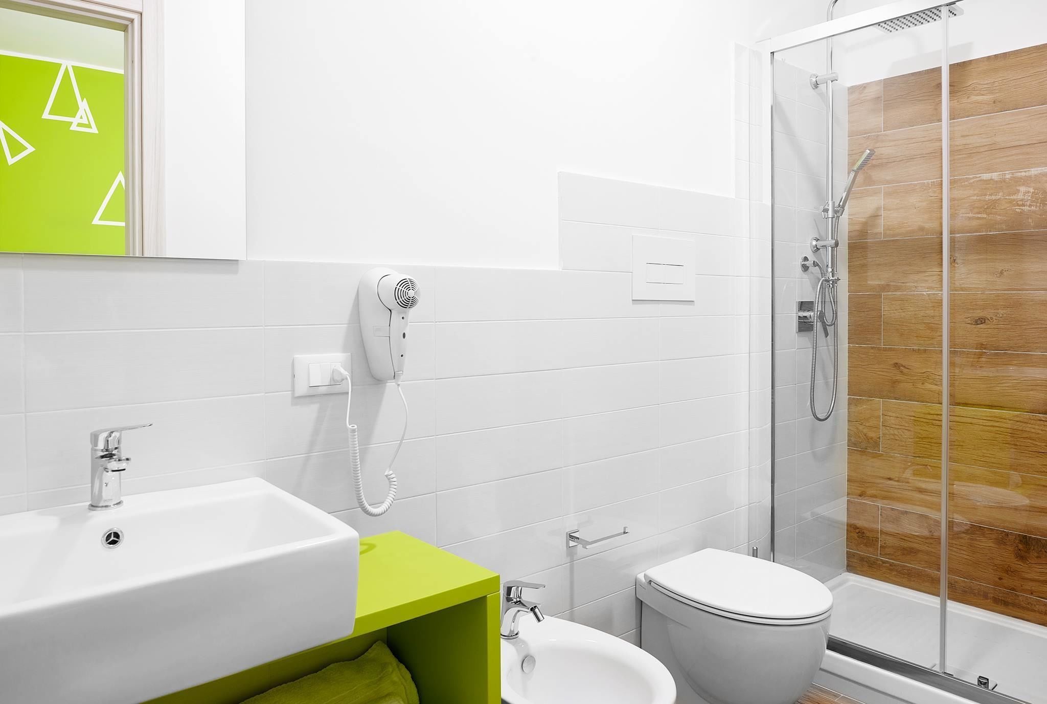 Et moderne badeværelse med bruser, toilet og vask.