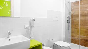 A modern bathroom with a shower, toilet, and sink.