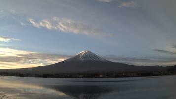 Una montaña con un lago al frente y un muelle con barcos.