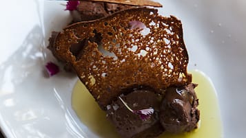 A dessert on a white plate with a drizzle of sauce.