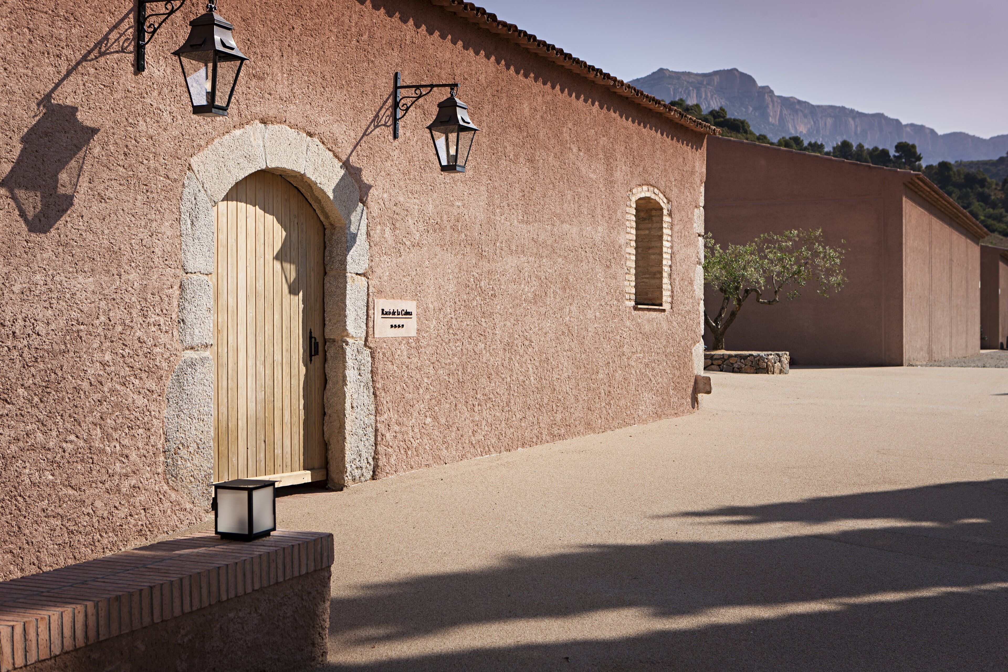 A building with a wooden door, a sign, and a lantern.