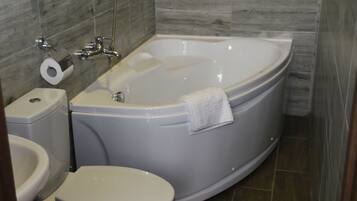 Un baño con bañera, inodoro y lavamanos.
