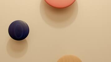 Three spherical objects of different sizes and colors on a plain surface.