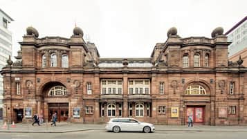 A historic building with a symmetrical facade, large arched windows, and decorative stonework.