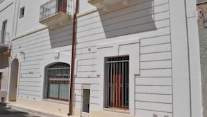 A white building with a balcony, a window with bars, and a door. - Novecento B&B (Massafra)
