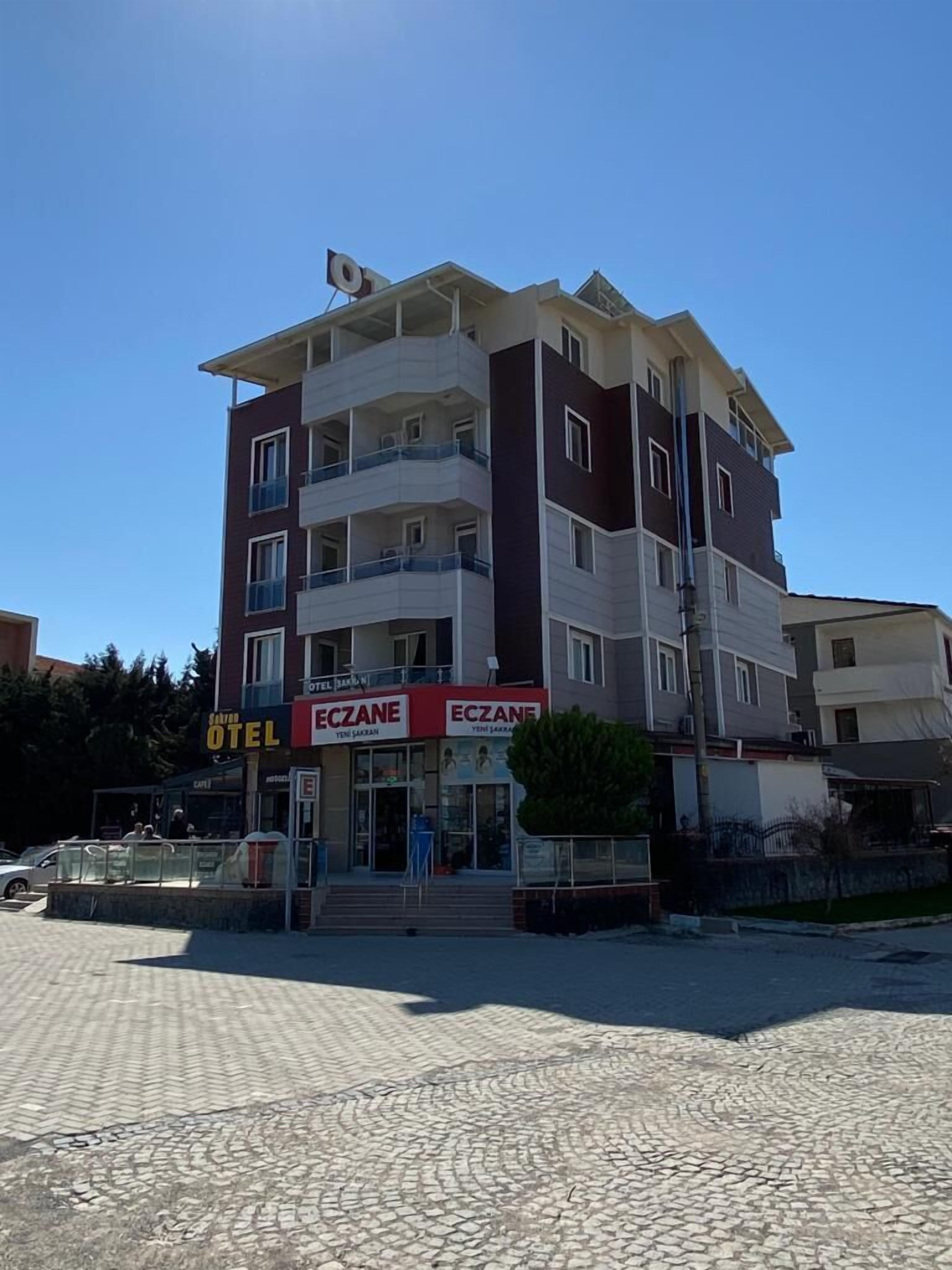 A multi-story hotel with balconies, a ground-level cafe, and a visible entrance.