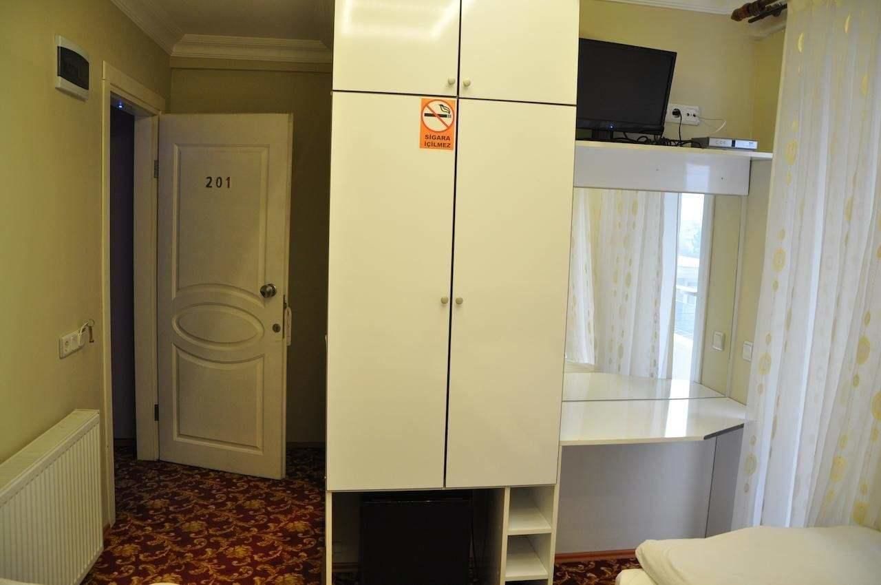 A room with a wardrobe, a bed, a radiator, and a door labeled 201.