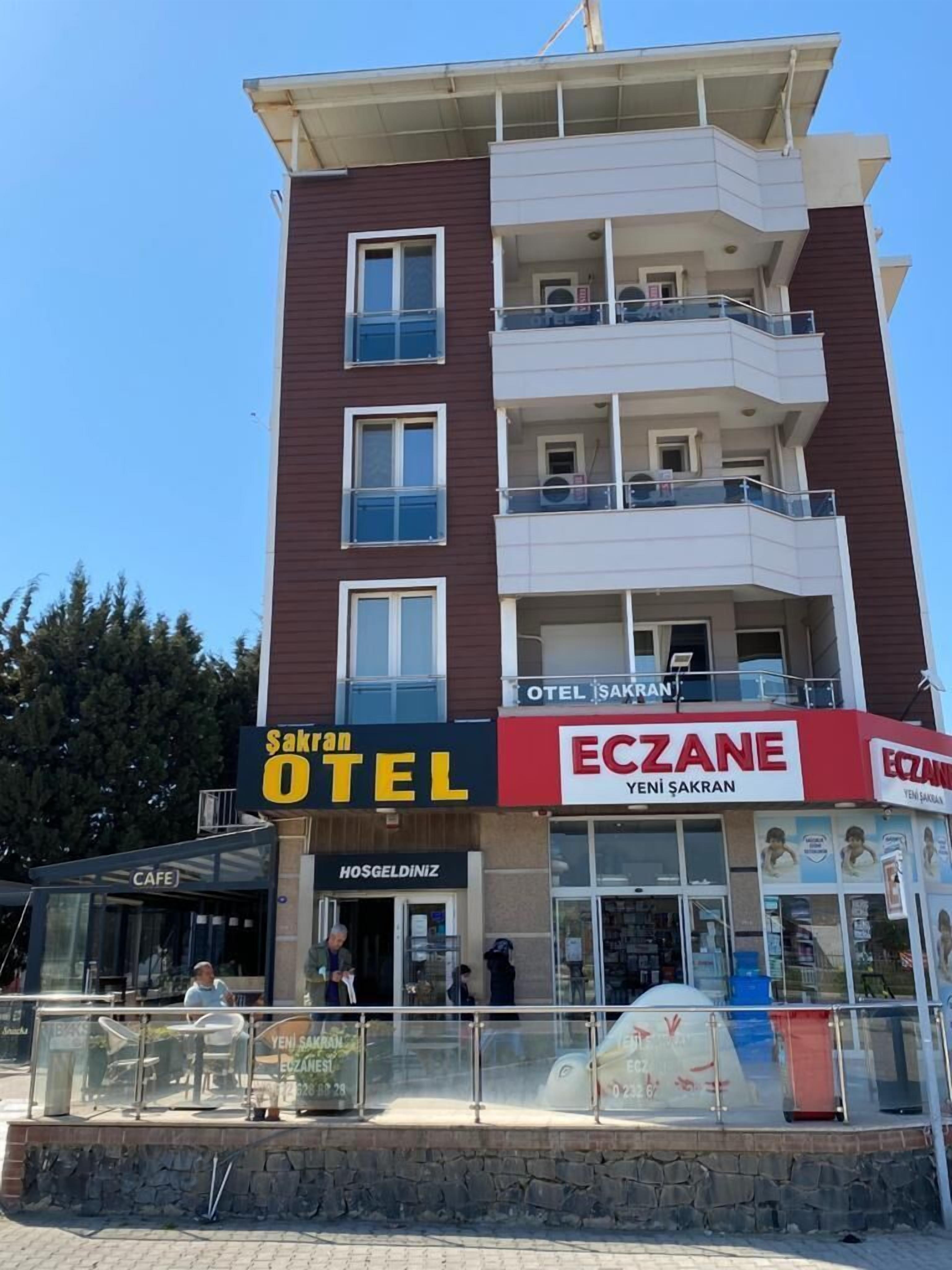 A multi-story building with a cafe and a hotel named "Sakran Otel" on the ground floor.