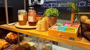 A breakfast buffet with various food items, including pastries, meats, and condiments.