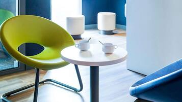 A modern room with a round table, a yellow chair, and a blue sofa.