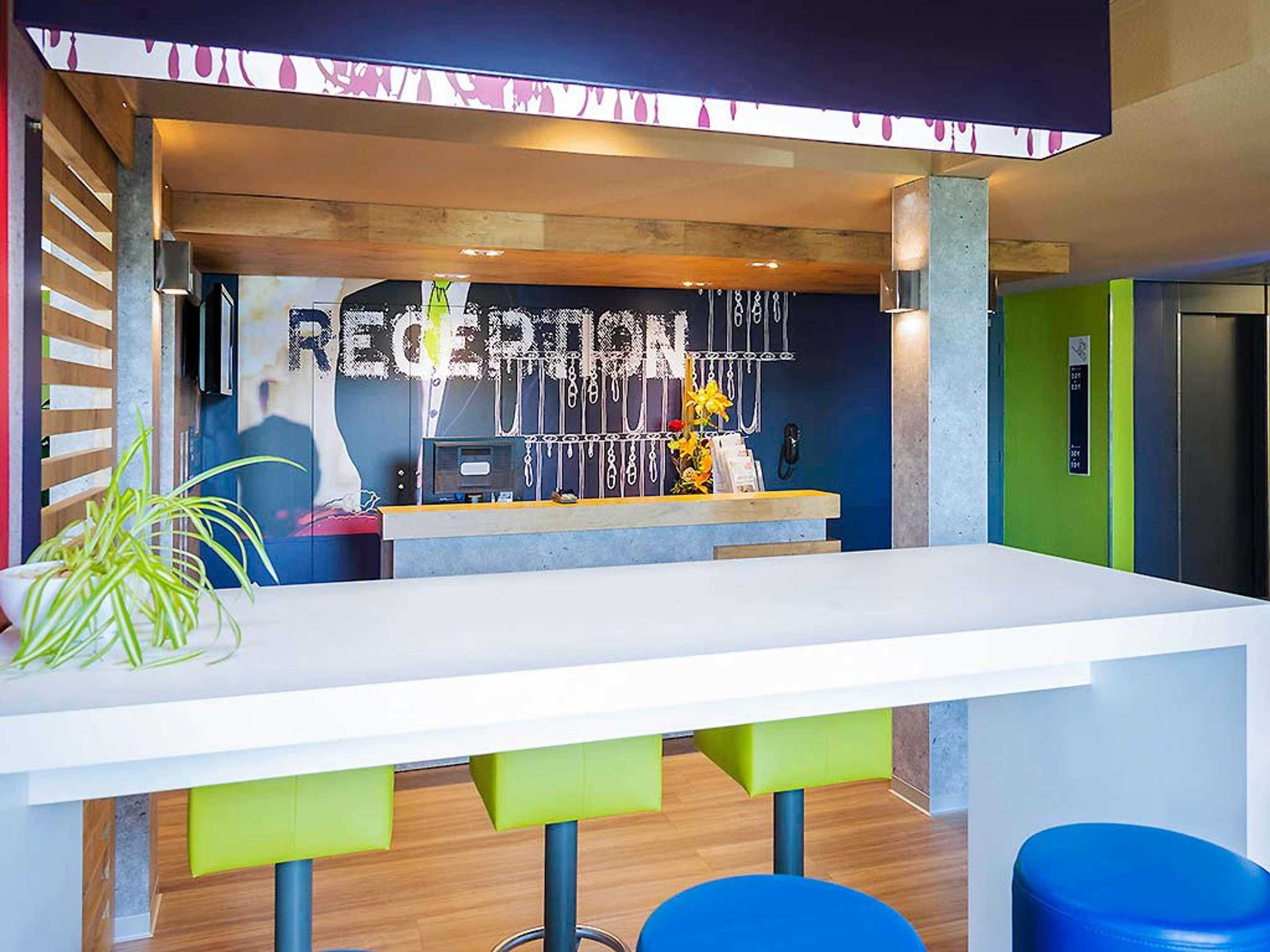 Un área de recepción con mostrador, teléfono y un cartel que dice 'RECEPTION'.