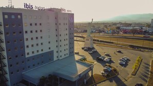 A hotel with a modern design, featuring a prominent 'ibis budget' sign on the roof. - Ibis Budget - Circuito da Fé (Lorena)