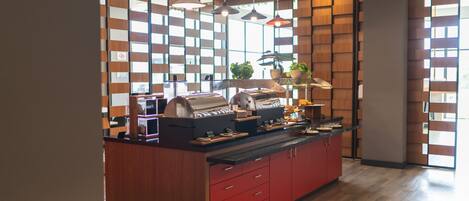 A modern kitchen with a central island, wooden panel walls, and pendant lighting.