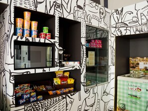 A vending machine with snacks and a microwave. - Ibis Budget - Circuito da Fé (Lorena)