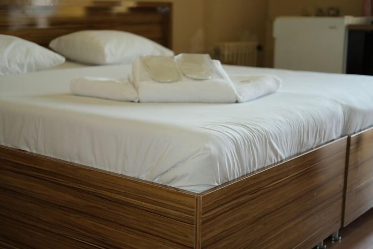 A neatly made bed with a wooden frame and white bedding.