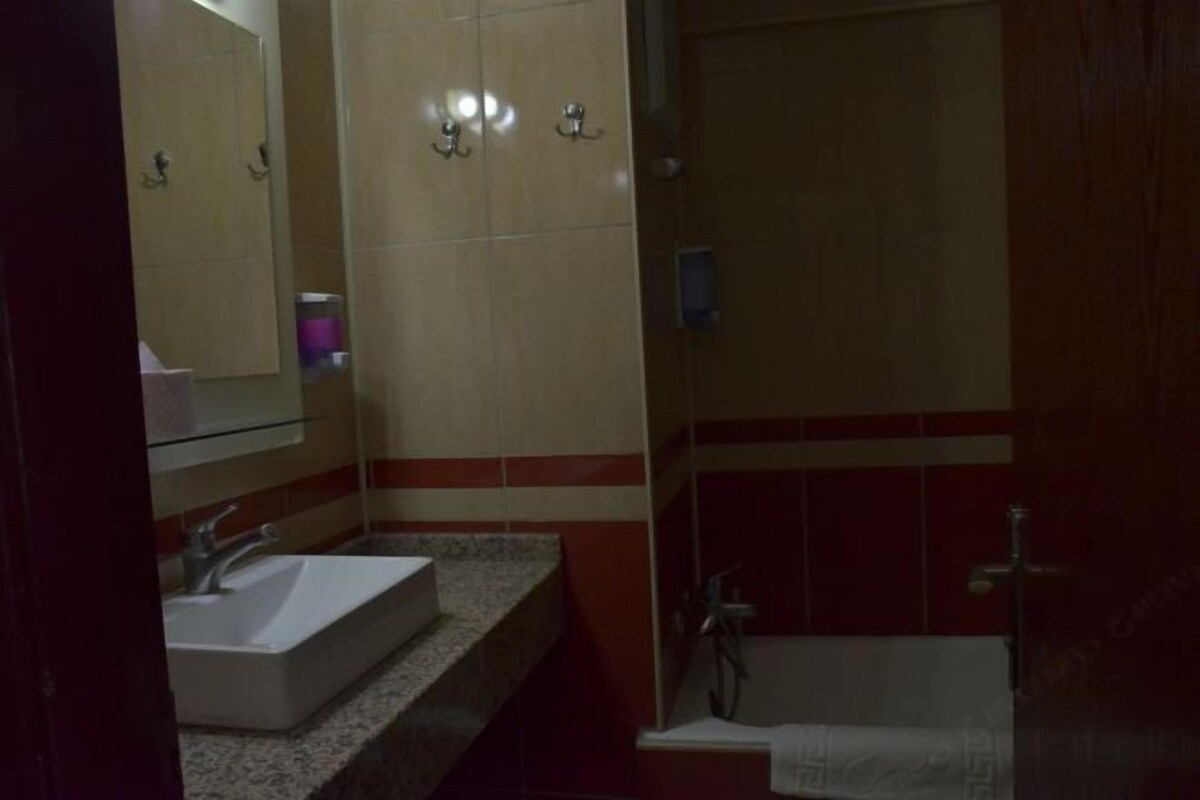 A bathroom with a sink, mirror, and shower.