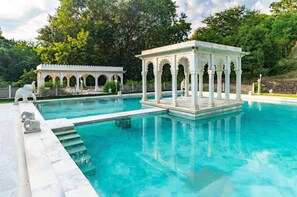 A large outdoor swimming pool with a pavilion and elephant statues. - The Fern Bambora Fort Udaipur, Bambora, Series by Marriott (Udaipur)