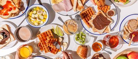 A breakfast spread with various foods and drinks on a table.