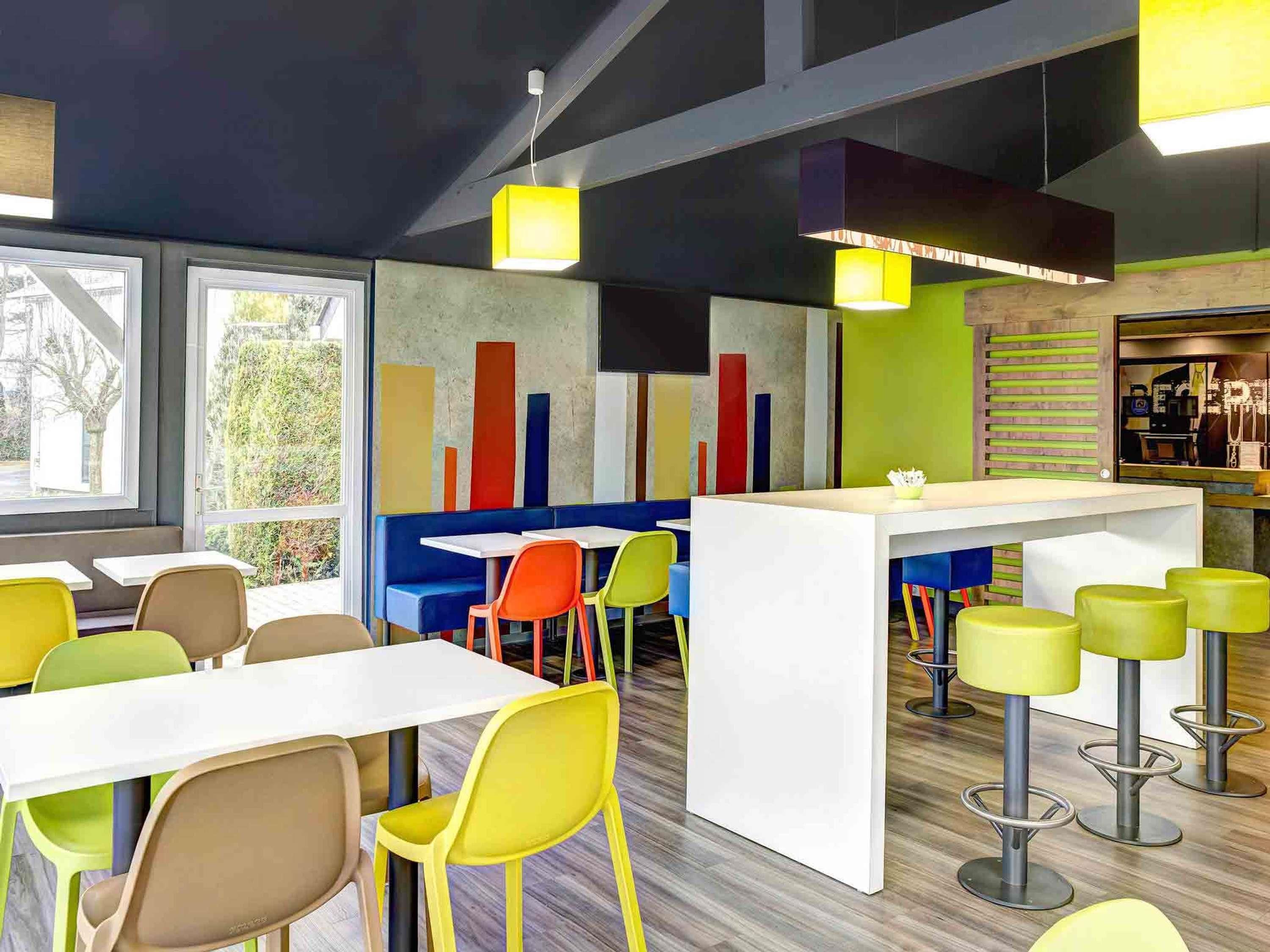 A modern interior with seating arrangements, a bar area, and a view through large windows.