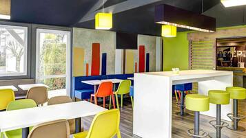 A modern interior with seating arrangements, a bar area, and a view through large windows.