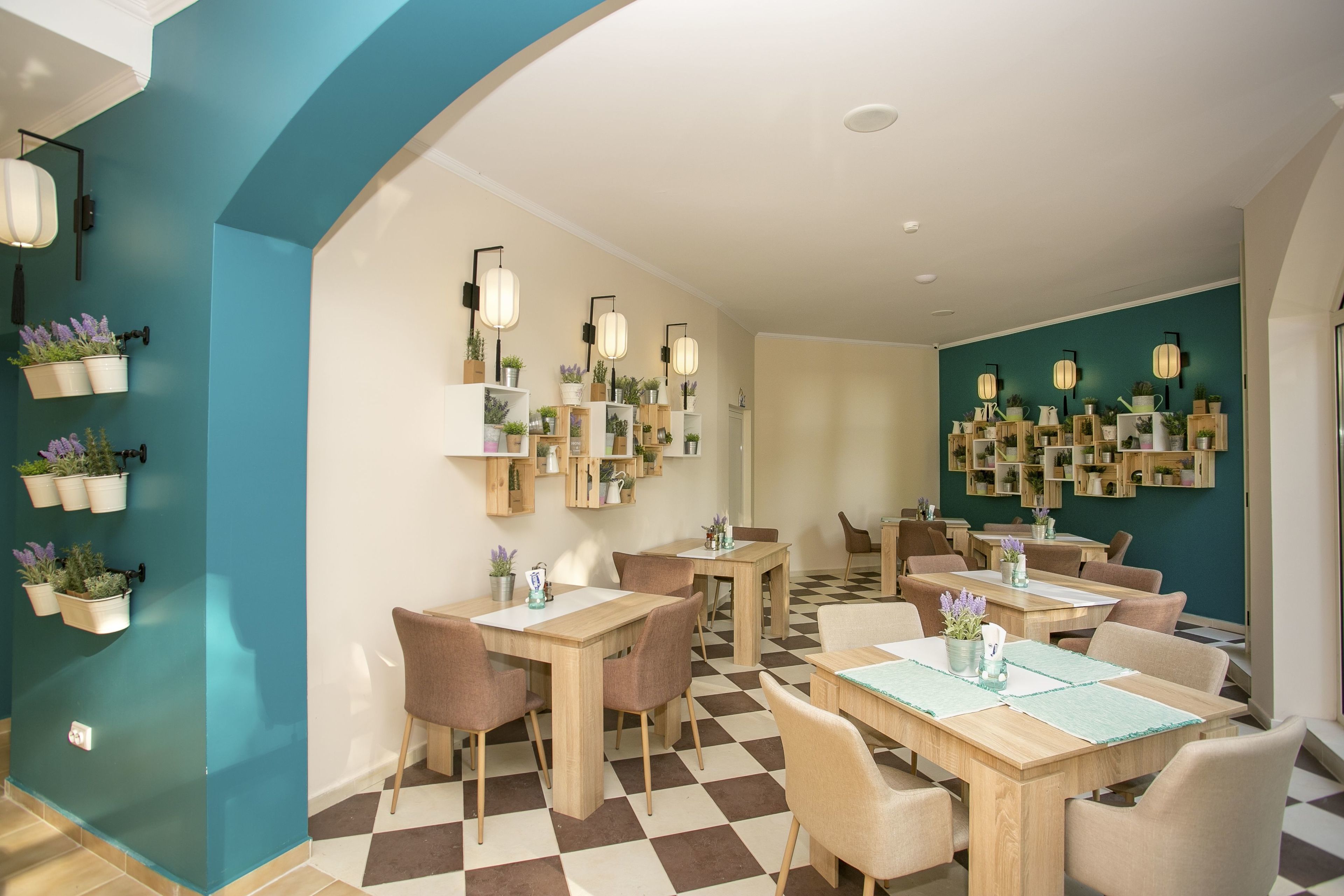 A modern dining area with checkered flooring, wooden tables, and chairs.