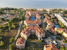 A large hotel with multiple buildings, a central courtyard, and a pool.