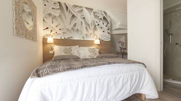 Camera da letto con un letto grande, due lampade da comodino, una testiera in legno e un pannello decorativo a parete.