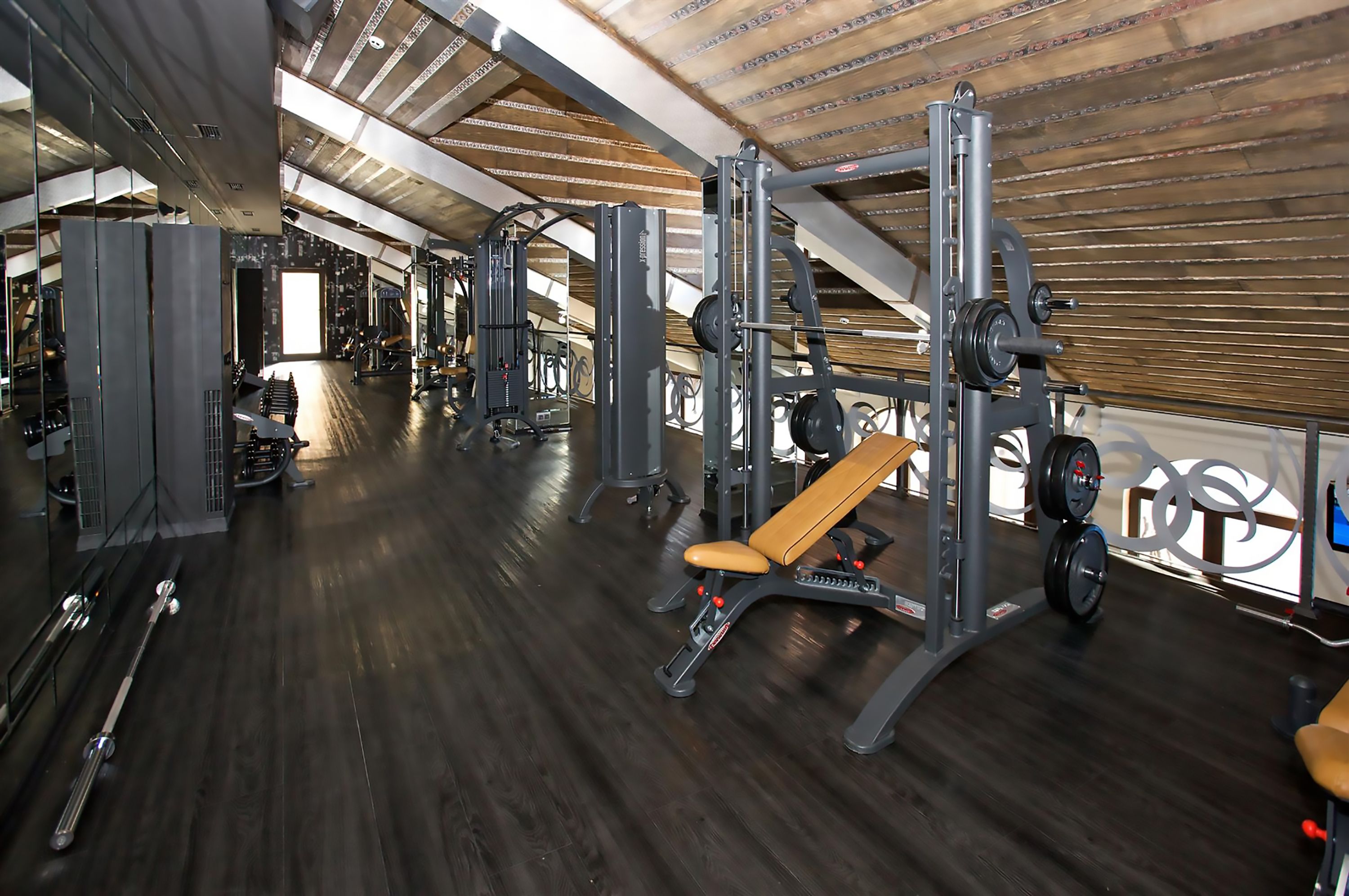 Un gimnasio con varios equipos de ejercicio, incluyendo bancos y máquinas de pesas.