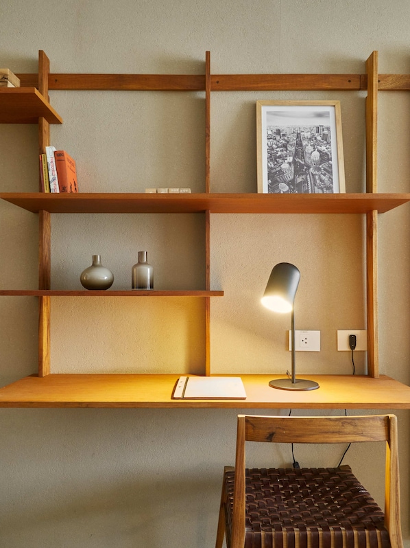 A wooden desk with shelves, a lamp, and a chair. - AQ Tailored Suites (Buenos Aires)