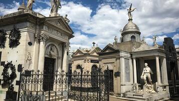 A historical building with classical architecture, featuring statues, columns, and ornate decorations.