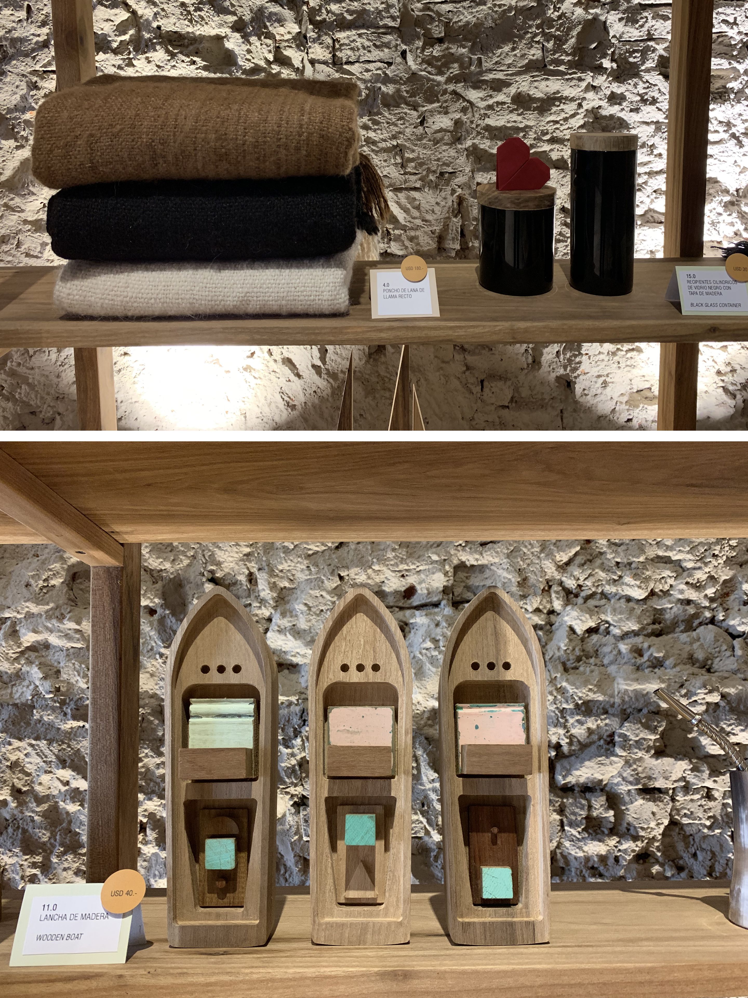 Wooden shelves displaying items like folded towels, a black glass container, and wooden boats.