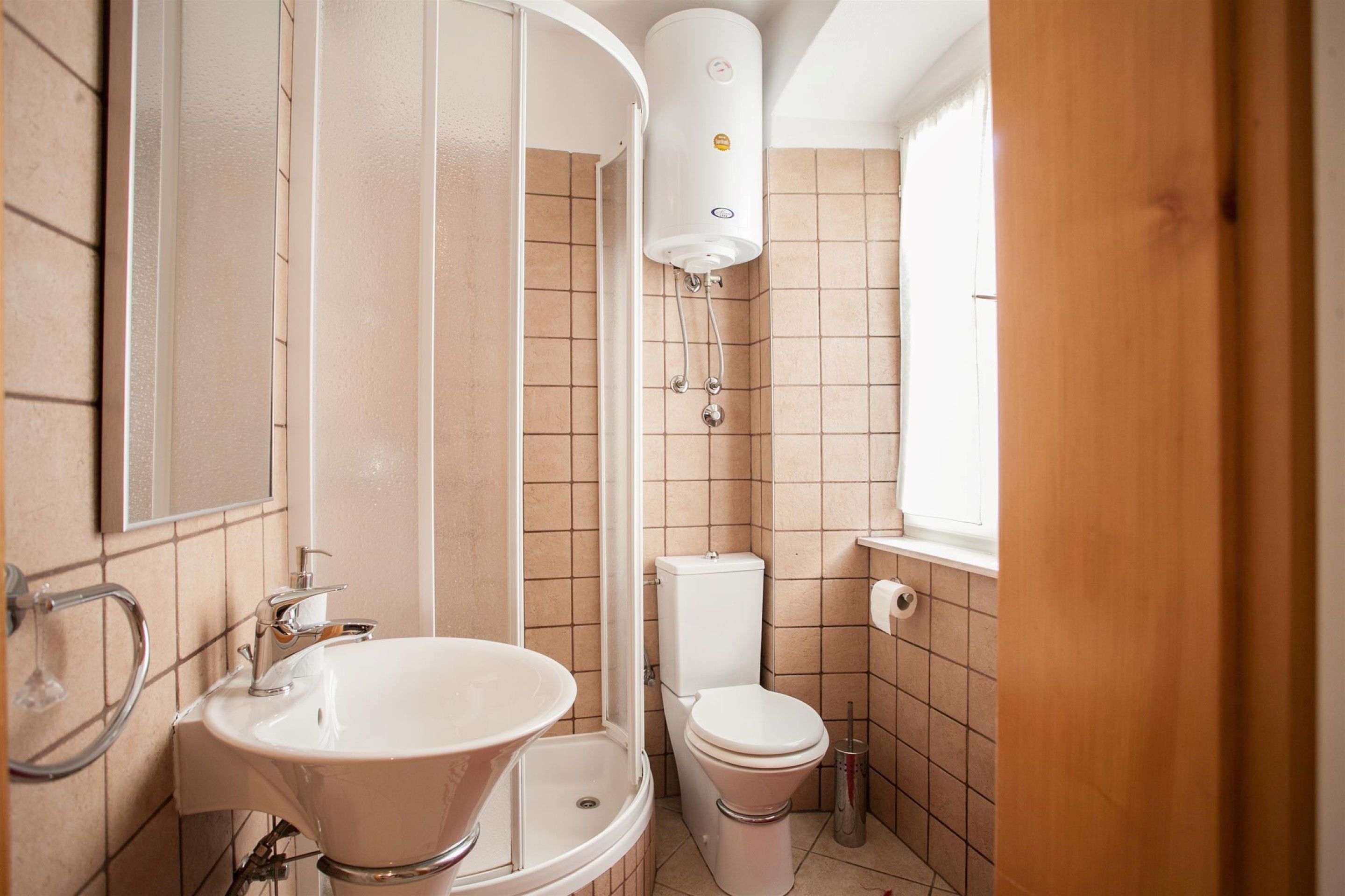 Un baño pequeño con lavamanos, inodoro y ducha.