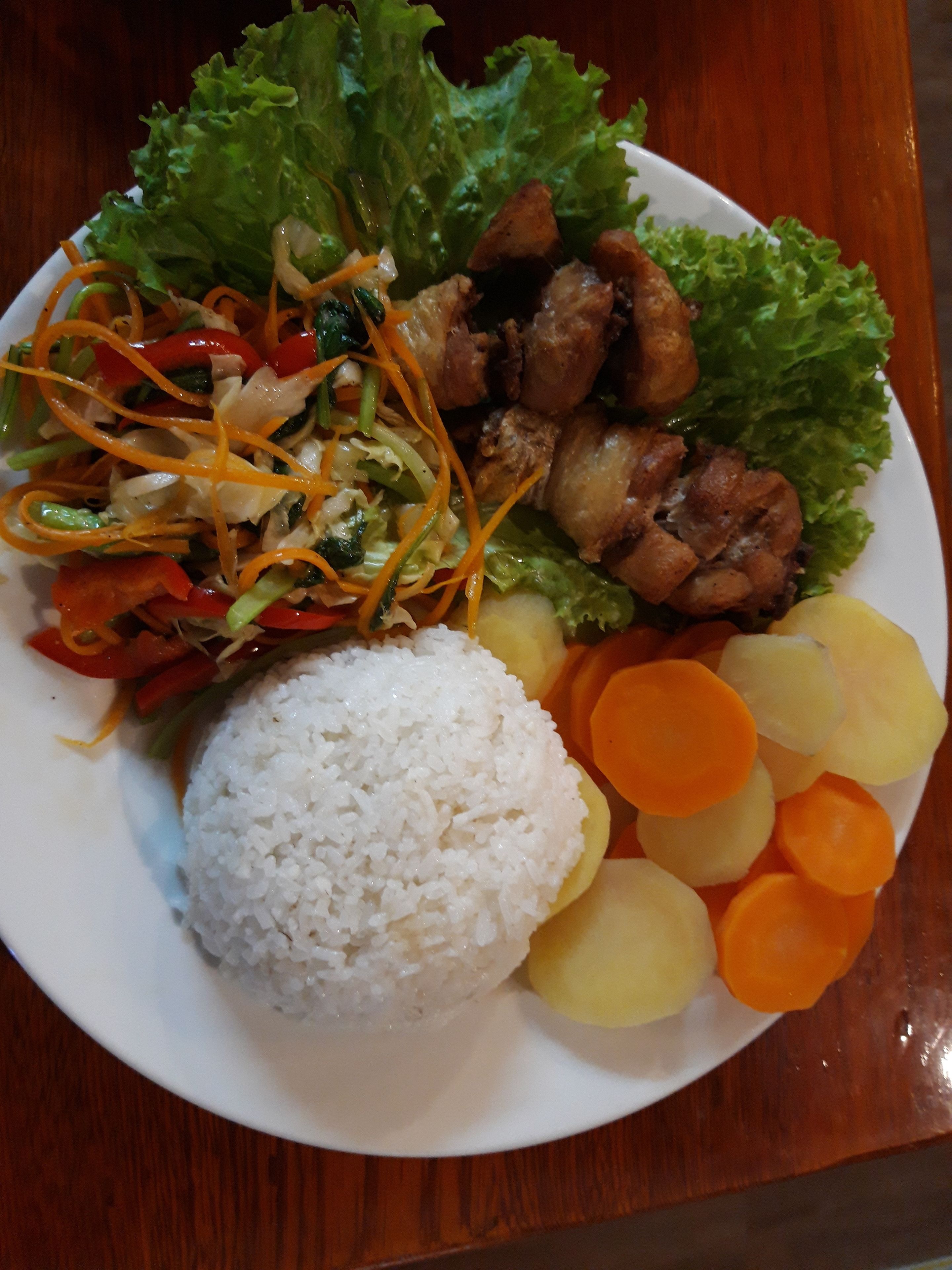 A plate of food with rice, vegetables, and meat.