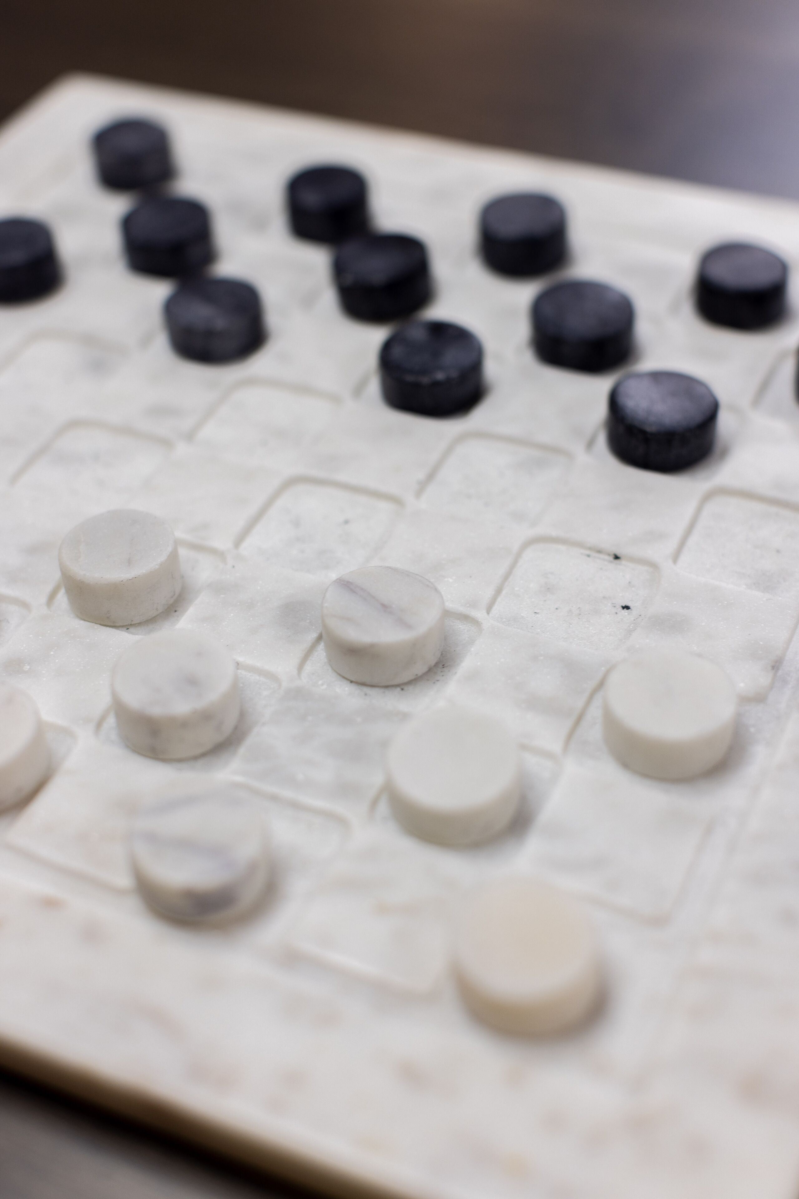 Primer plano de un tablero de ajedrez con piezas blancas y negras alternadas.