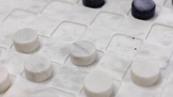 Primer plano de un tablero de ajedrez con piezas blancas y negras alternadas.