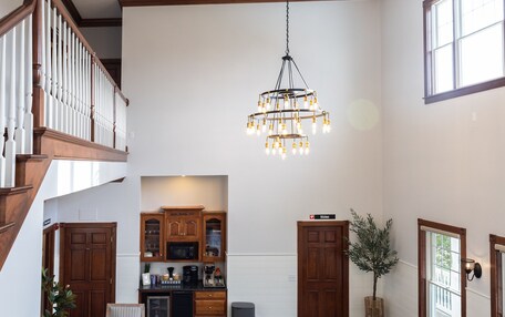 A spacious living area with a dining table, kitchen, and staircase.