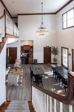 A spacious living area with a dining table, kitchen, and staircase. - Hillside Villa Ohio (Millersburg)