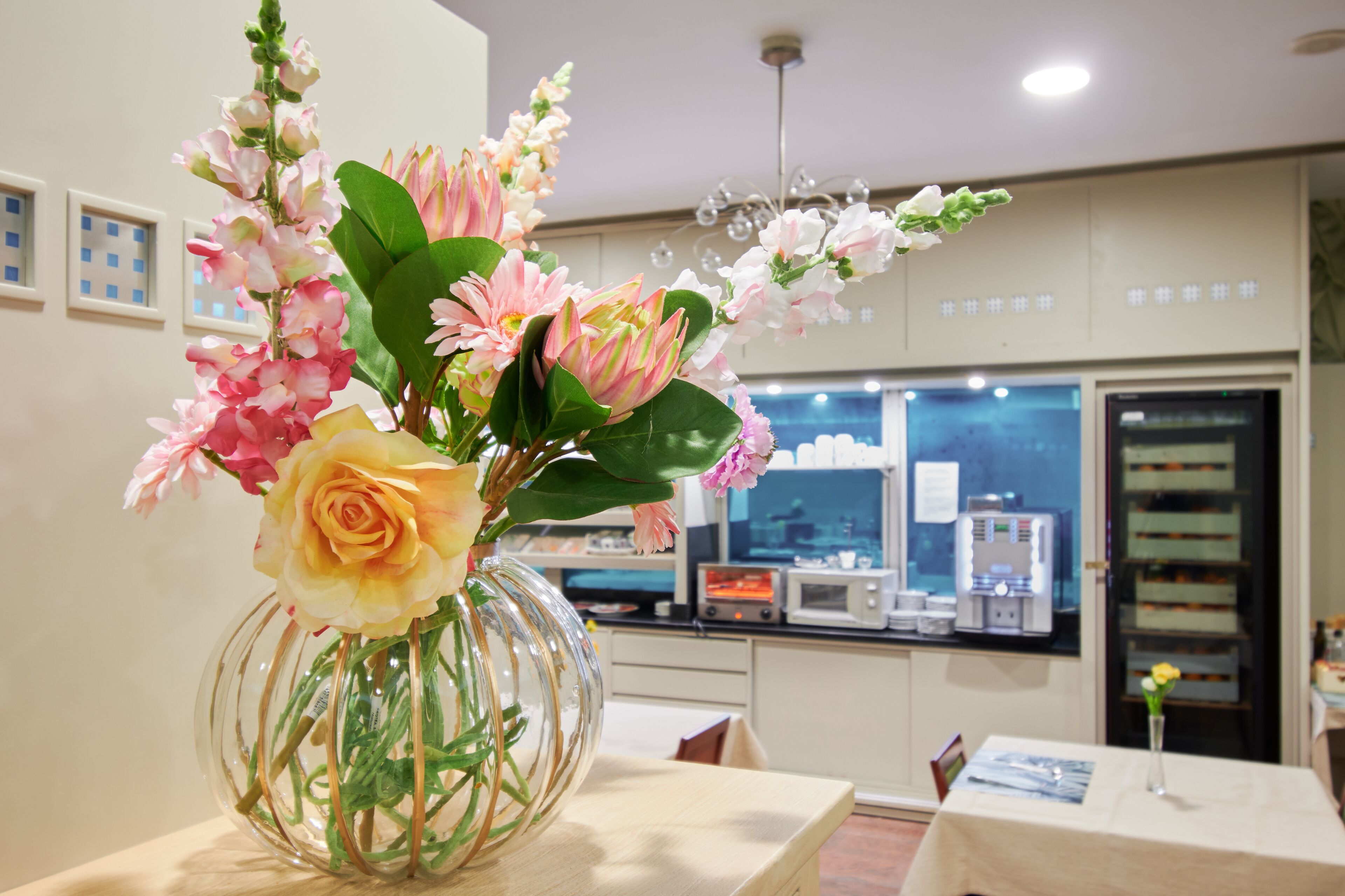 A room with a table featuring a vase of flowers.