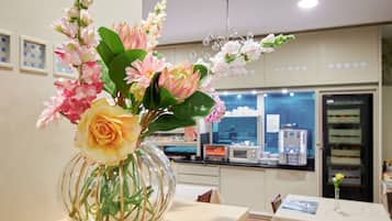 A room with a table featuring a vase of flowers.