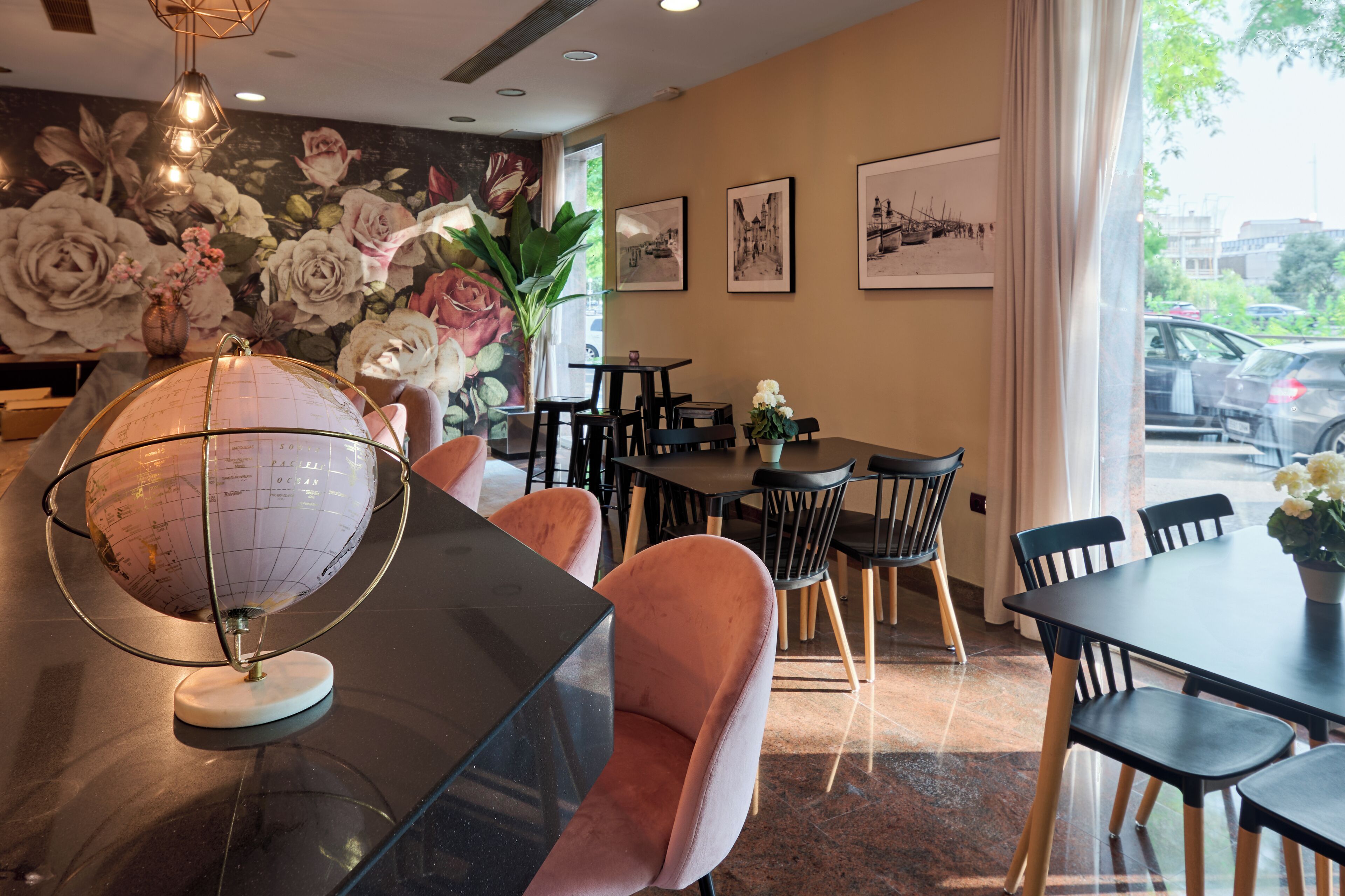 A dining area with a globe, cushioned chairs, and a mural of flowers.