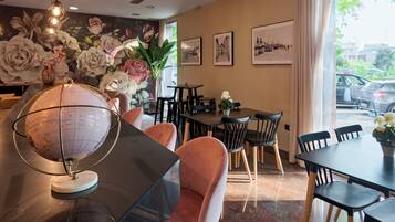 A dining area with a globe, cushioned chairs, and a mural of flowers.