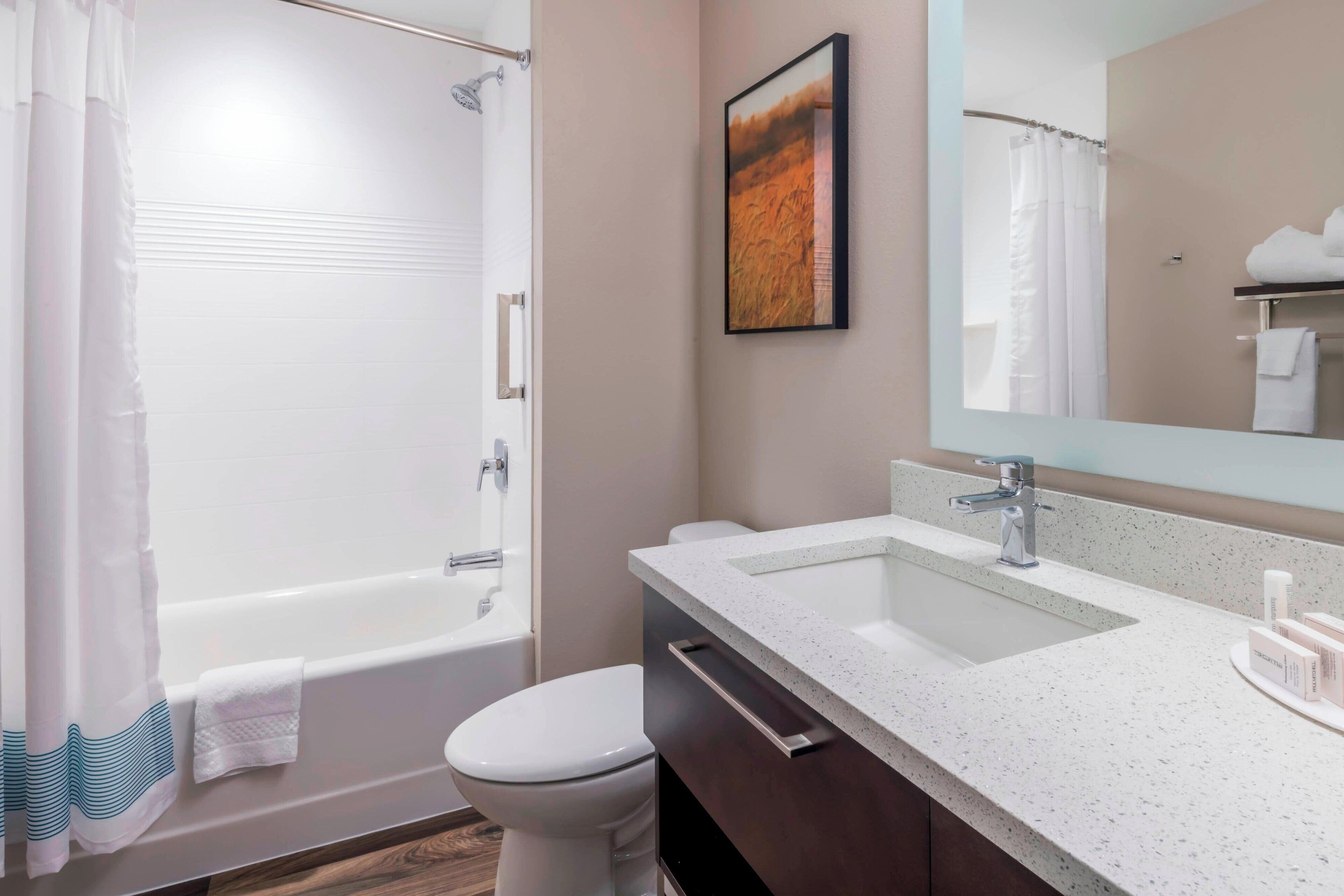 A modern bathroom with a bathtub, toilet, and sink.