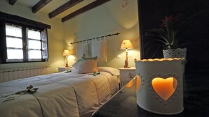 A bedroom with a bed, bedside lamps, a window, and a decorative heart-shaped light fixture. - Posada Reserva Verde (Los Tojos)