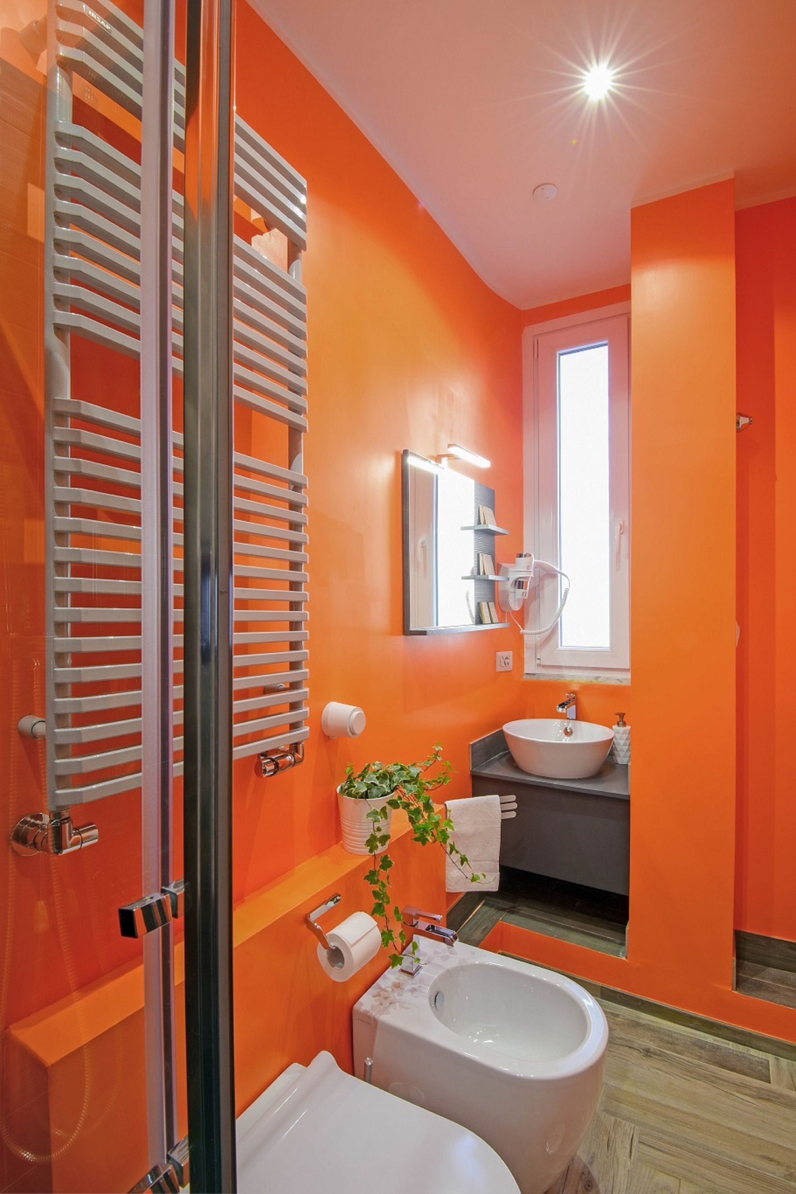 Un baño con un lavabo blanco, un inodoro y una cabina de ducha de vidrio.