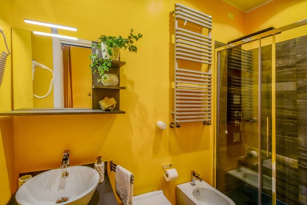 A bathroom with two sinks, a mirror, a towel rack, and a glass shower enclosure. - Allegras House Caracciolo (Rome)