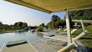 A poolside area with lounge chairs and a pergola. - Agriturismo La Montecchia (Selvazzano Dentro)